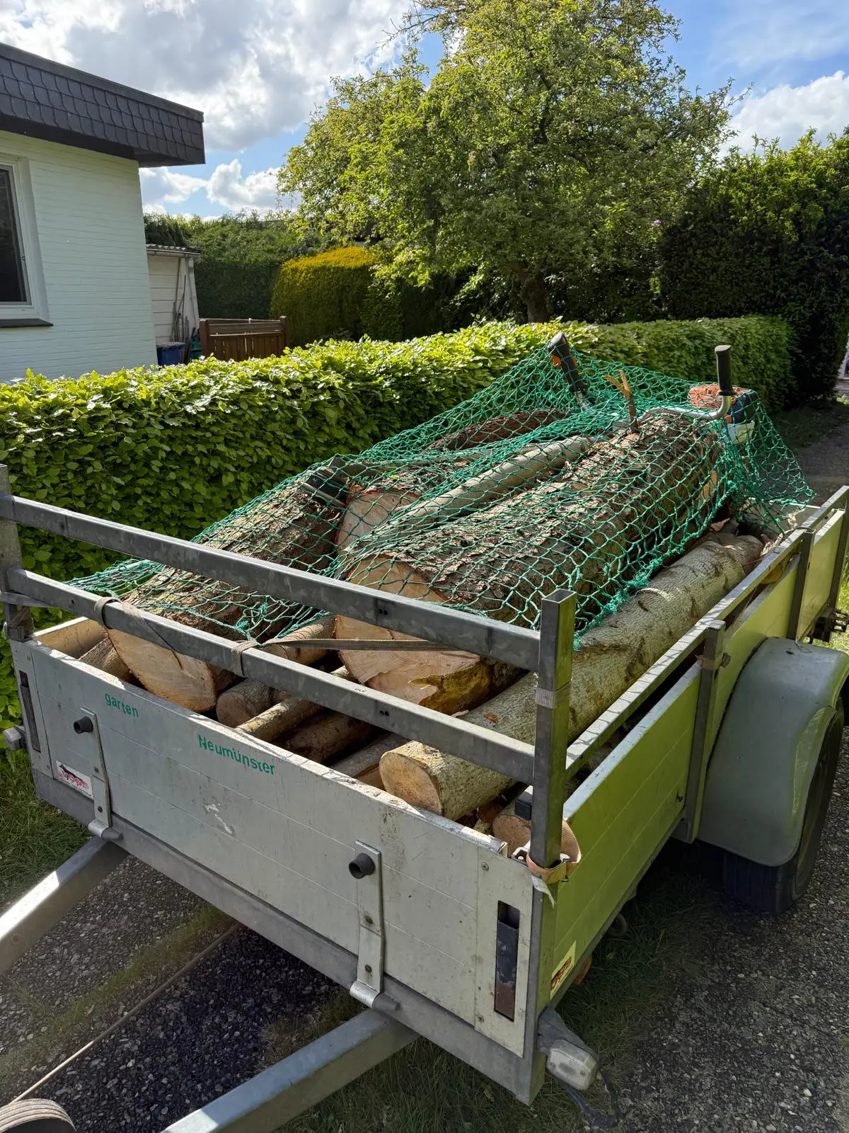 Anhänger beladen mit Stammholz nach dem Baumschnitt